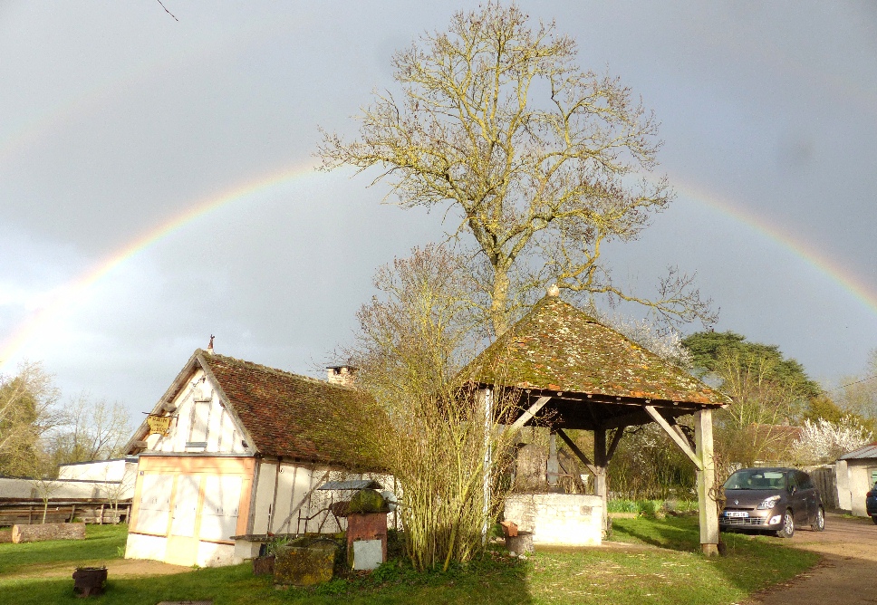 Un arc-en-ciel double entre deux giboules